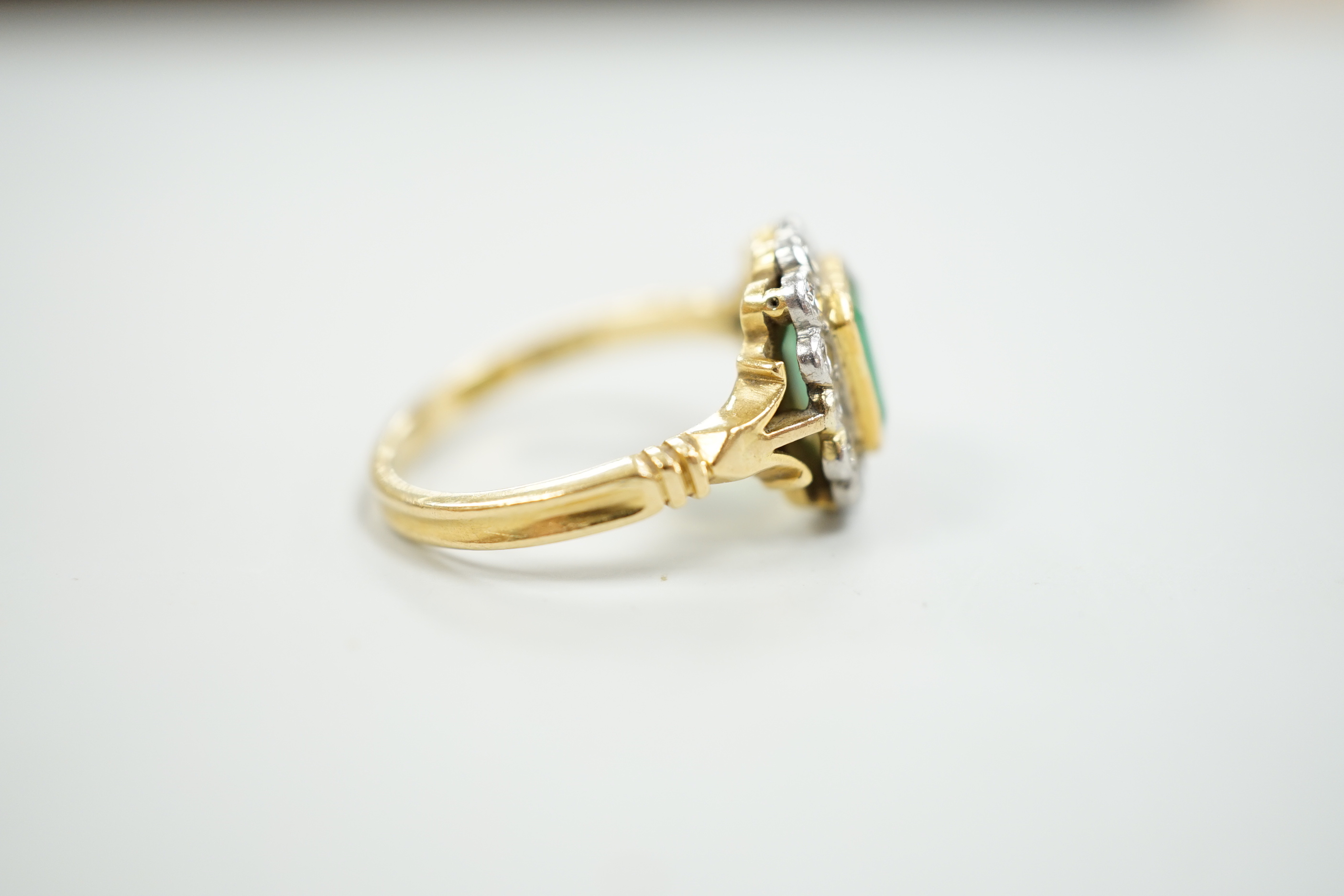 A modern 18ct gold, emerald and diamond set circular cluster ring, size O, gross weight 5 grams.